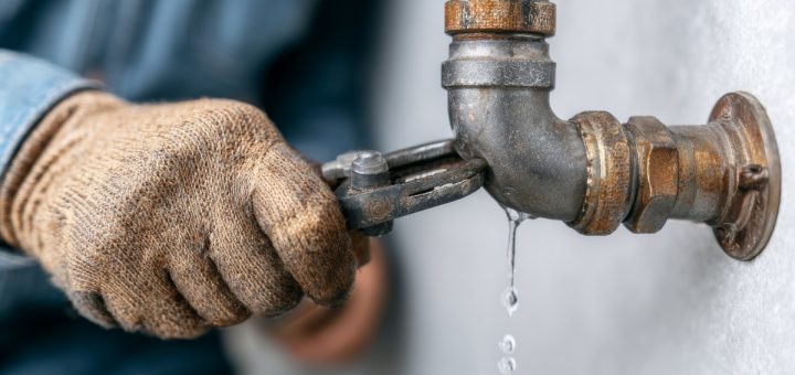 close-up of a man fixing a leaking pipe